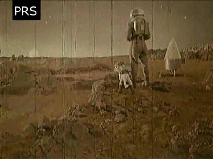 A man and his dog watch the sun rise on Mars.