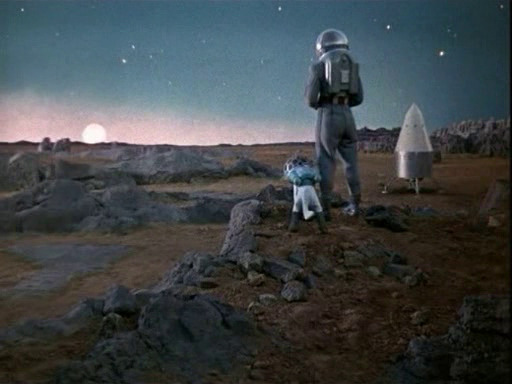 A man and his dog watch the sun rise on Mars.