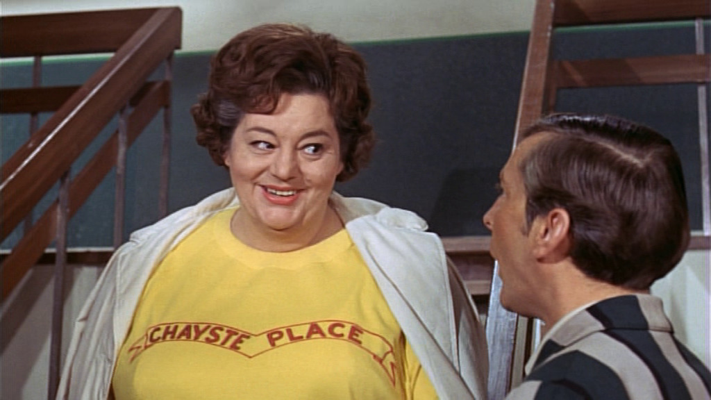 Hattie Jacques in a t-shirt that says 'Chayste Place' across the chest.