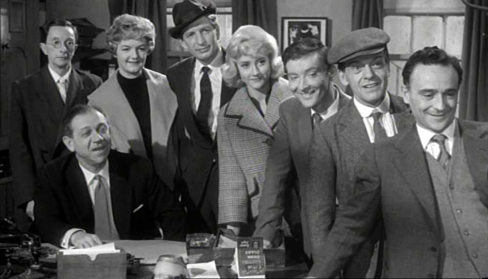 A crowd of Carry On regulars smiling and looking expectant.