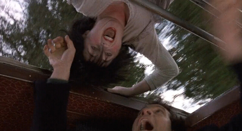 A woman screaming through the sun roof of a van.