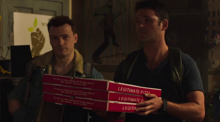 Two unappealing men holding Legitimate Pizza.