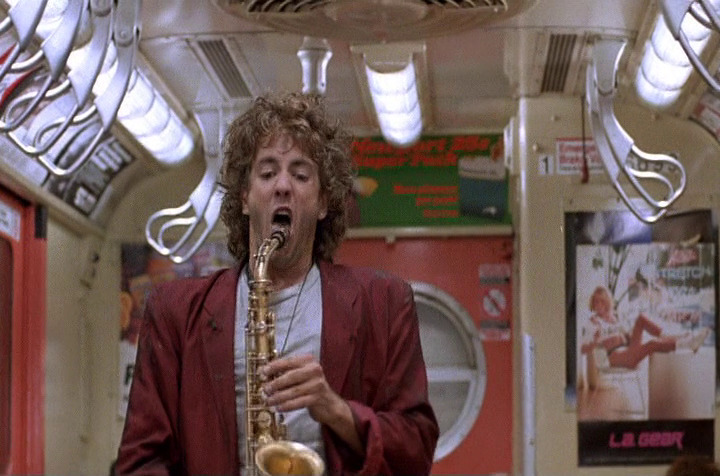Kaz on the subway with a saxophone.